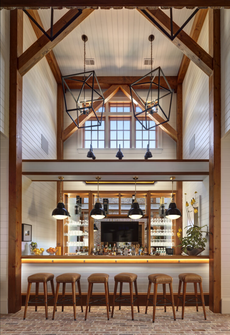 A very tall bar with wood beams and bar seats