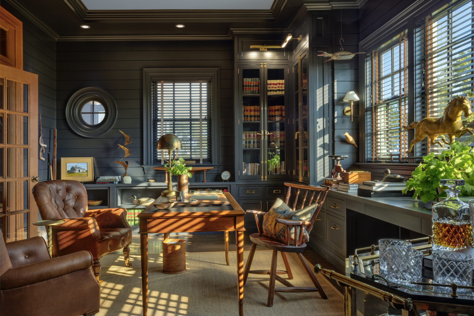 A dark teal study with warm wood furniture