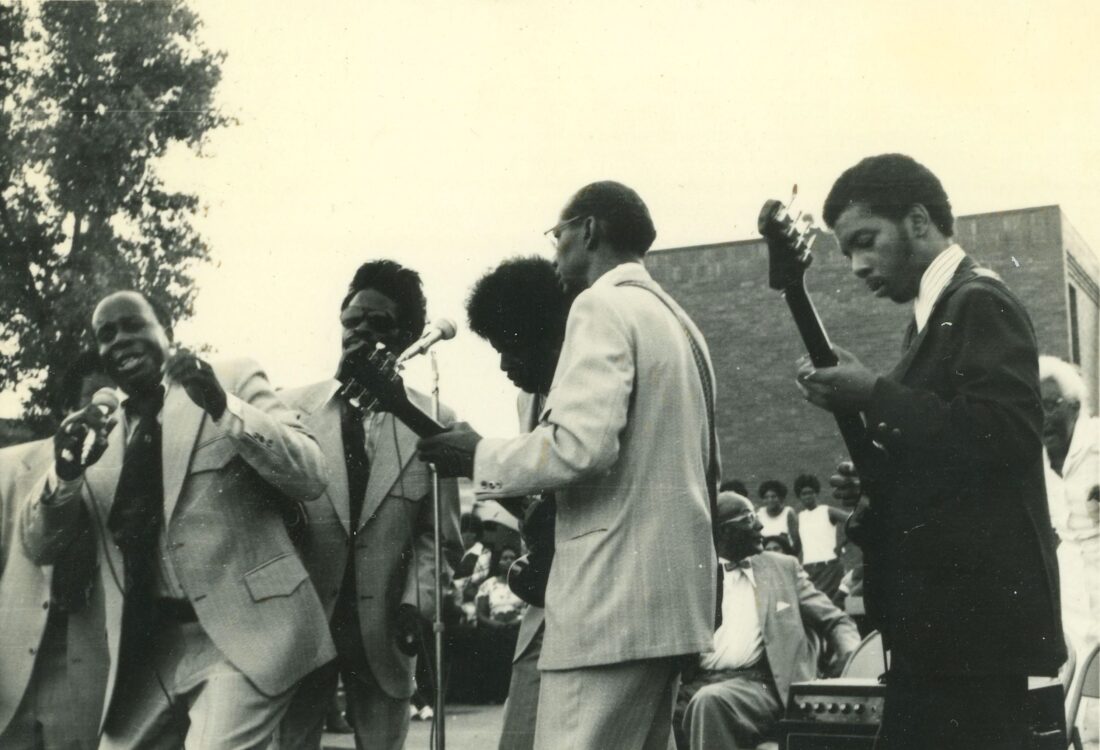 A group of men sing on a stage