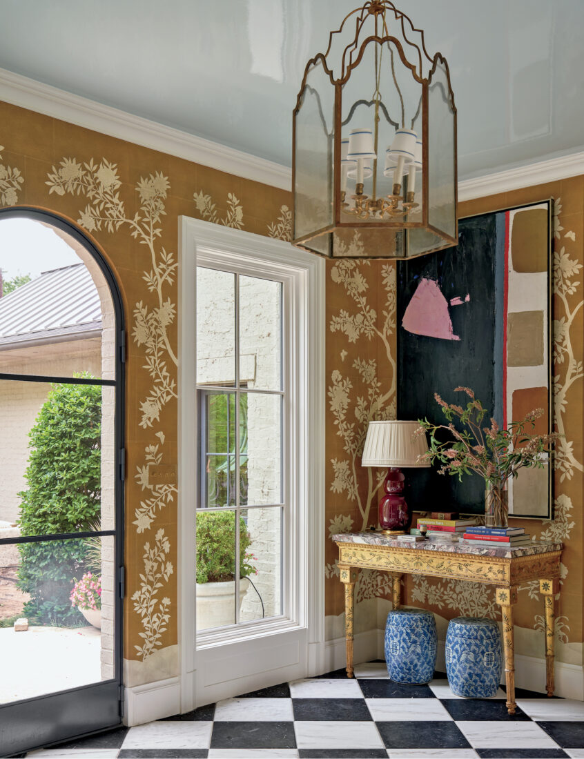 A dark mustard room with checkered floors and floral white wallpaper details on the deep yellow walls
