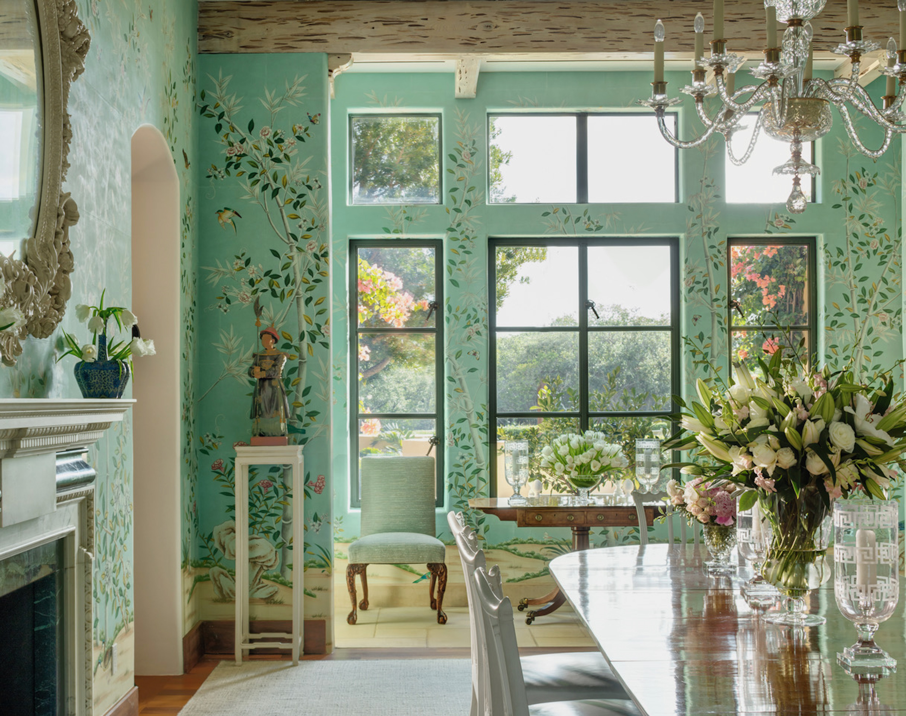 A green room with floral wallpaper and windows