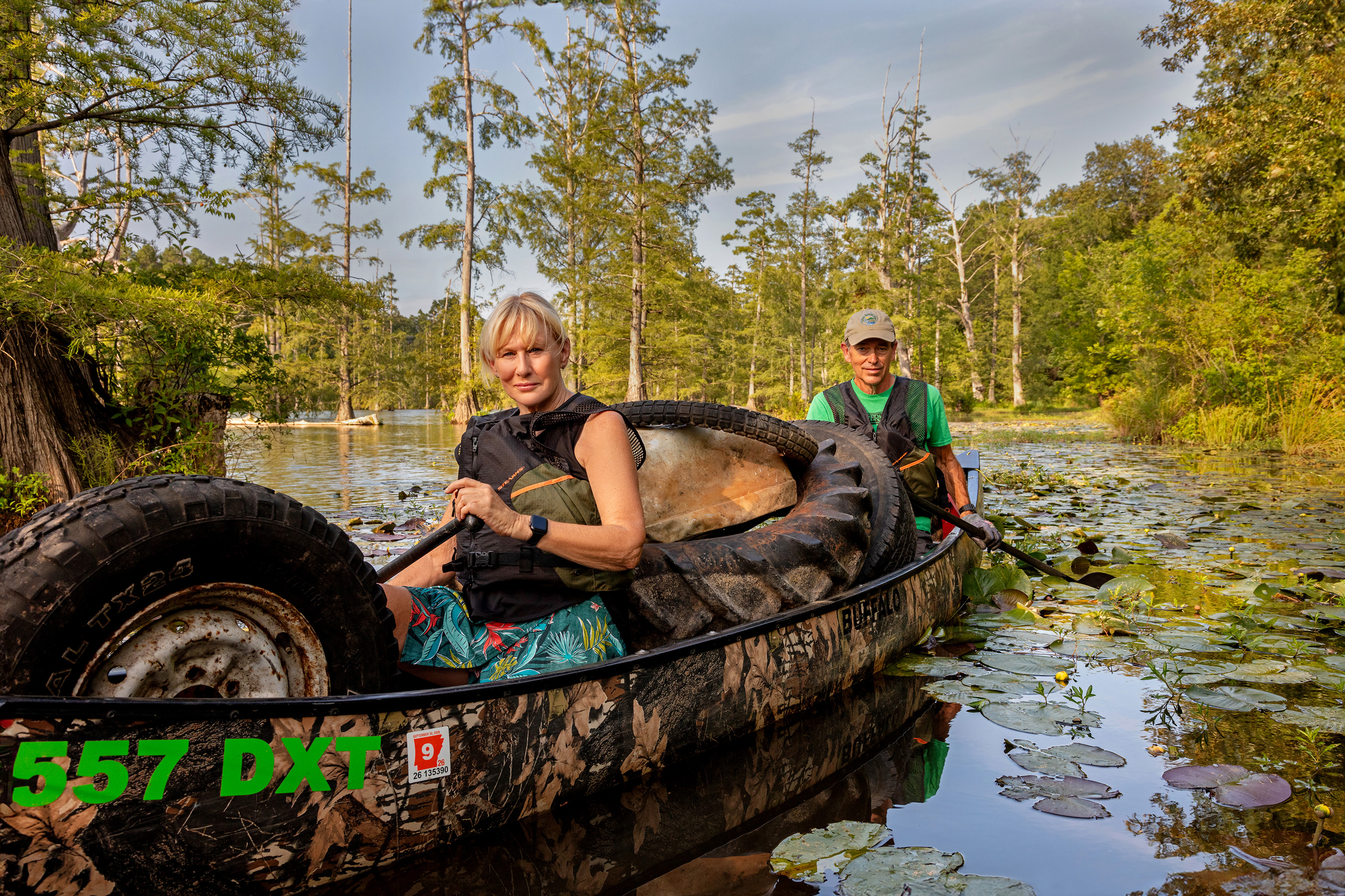 a couple sits in a canoe in a swampy landscape