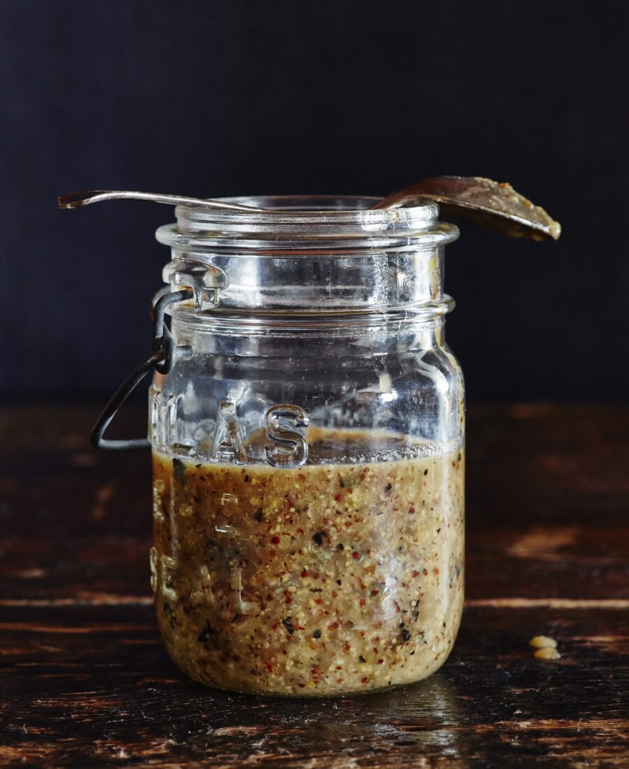 A mason jar halfway filled with Chunky Sweet Onion Jezebel Sauce.