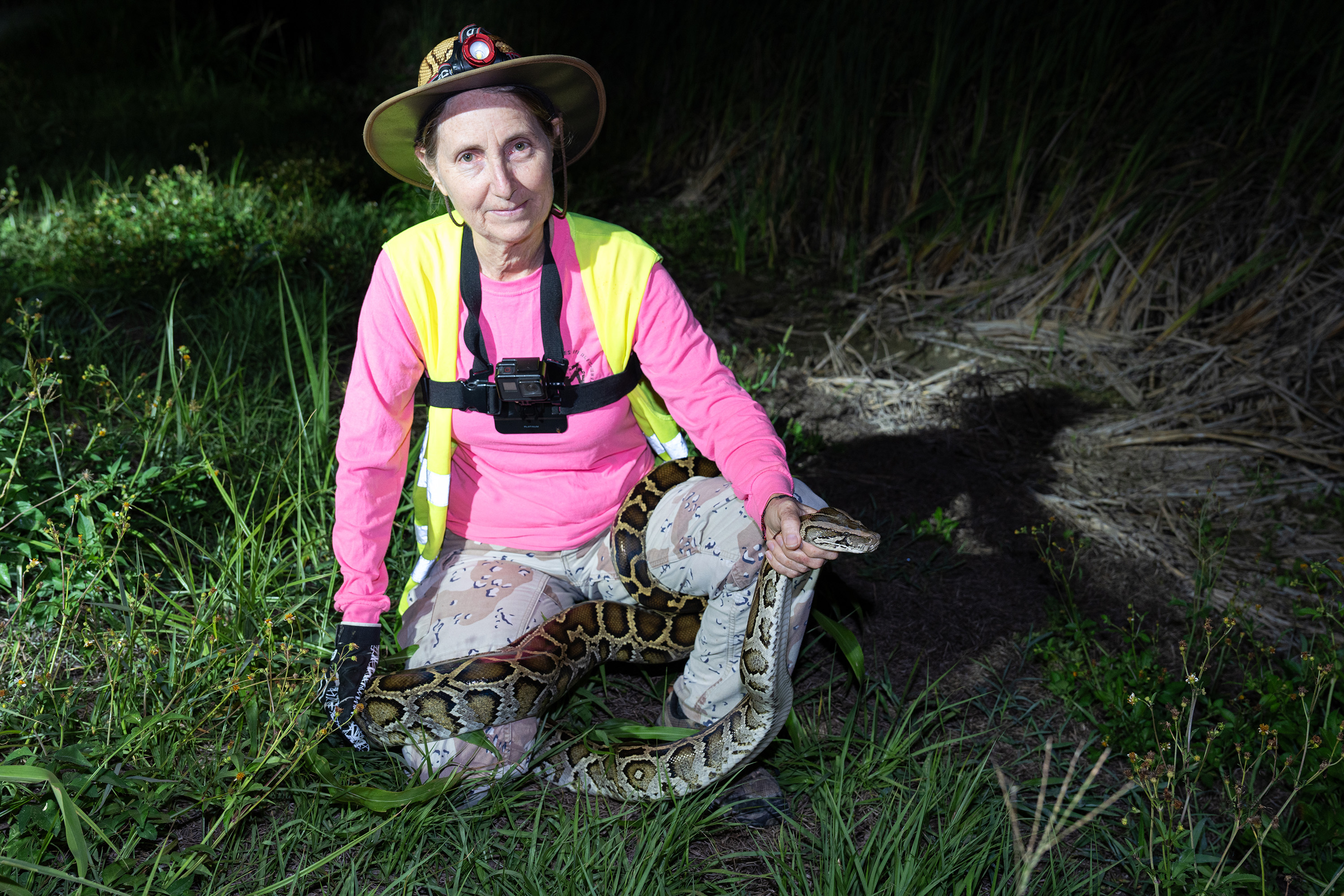 A woman holding a captured python