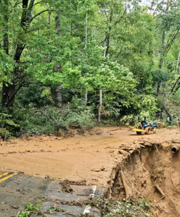 Mud covers a road, which has been partially washed away