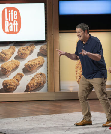 Two people stand on the stage of Shark Tank