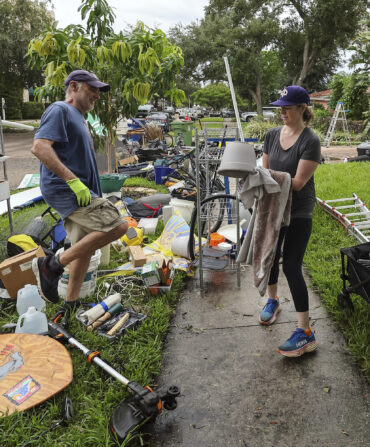 A group of people organize items that were impacted by flooding from Hurricane Helene.