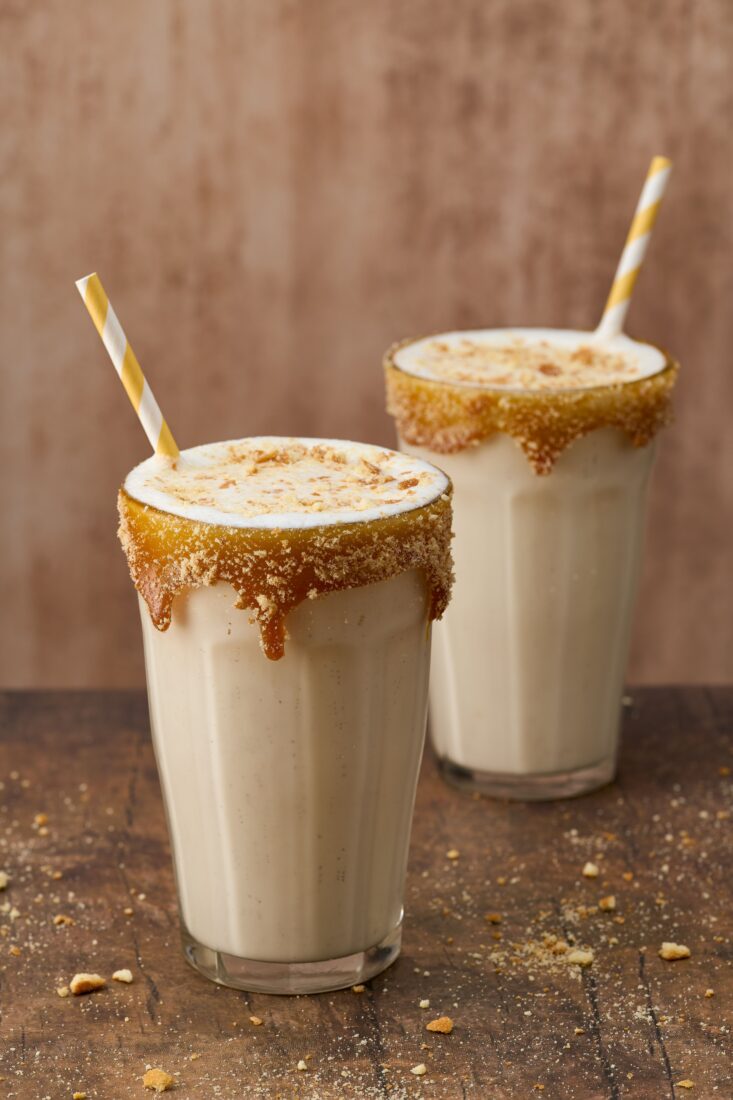 Two glasses of bourbon apple pie milkshakes.