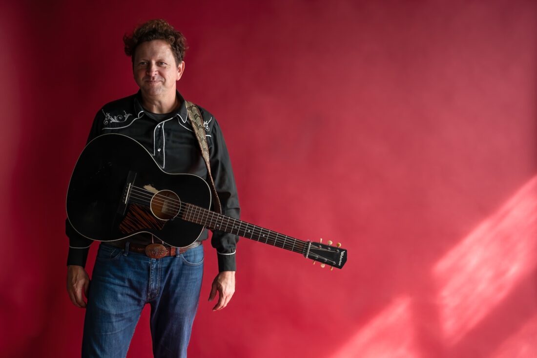 Folk Singer Abe Partridge poses with his guitar.