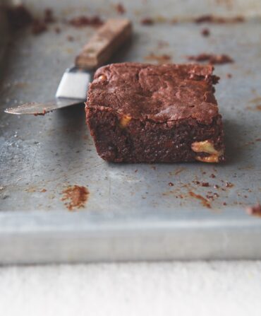 A singular pecan brownie on a tray