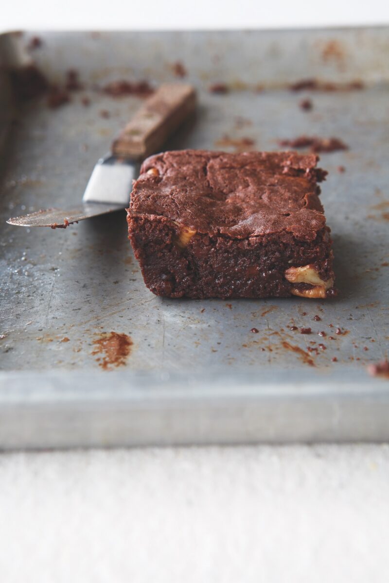 A singular pecan brownie on a tray