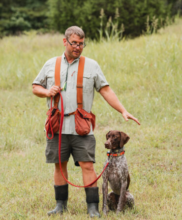 A man stands with a dog