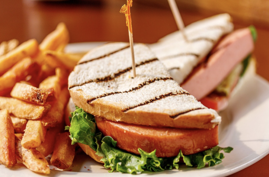 A smoked bologna sandwich on a plate with fries