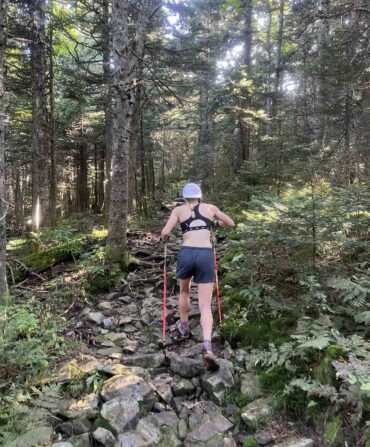 A woman hikes on a forested trail