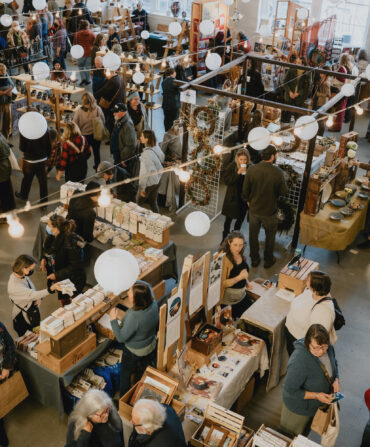 People gather in an art studio for a market