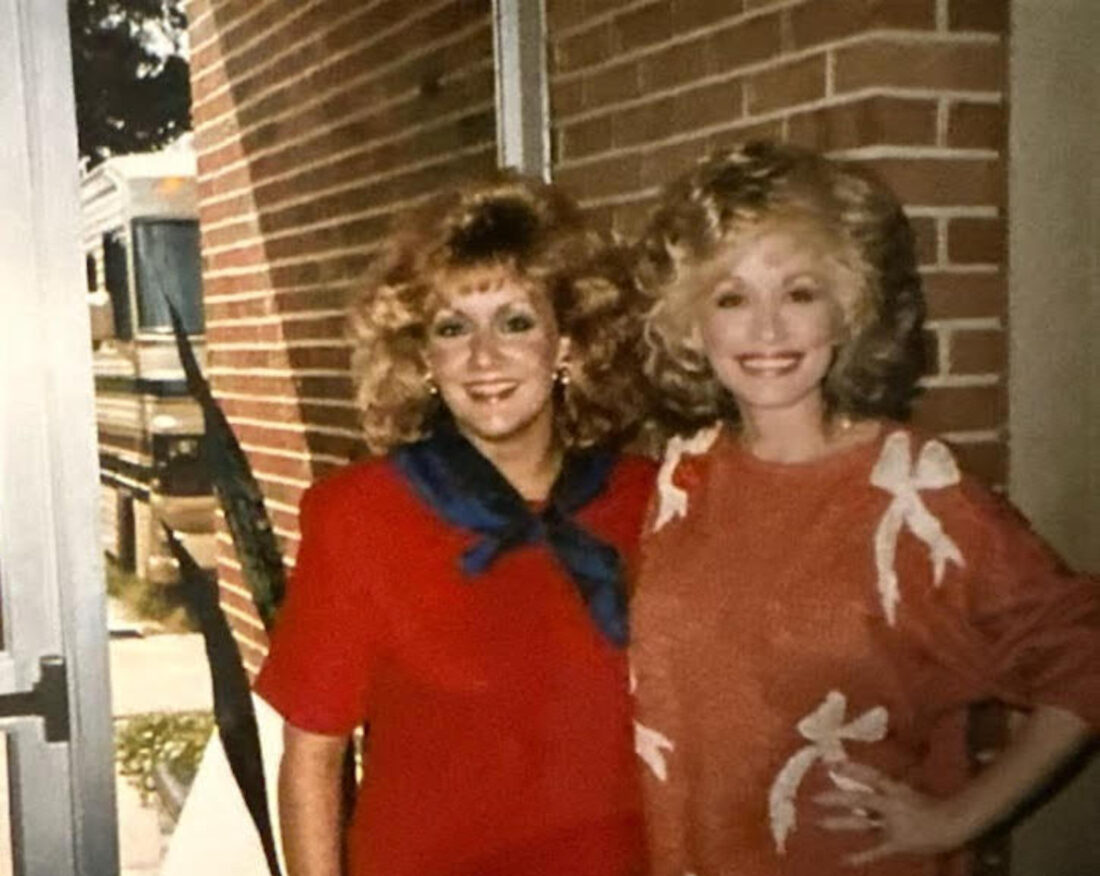 A portrait of a blonde woman with Dolly Parton