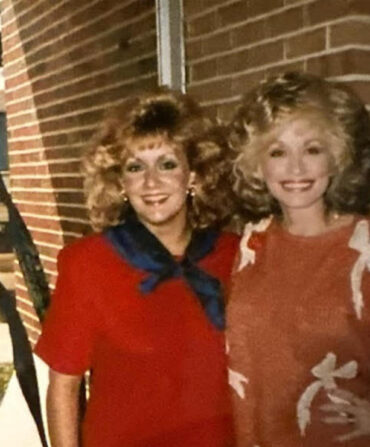 A portrait of a blonde woman with Dolly Parton