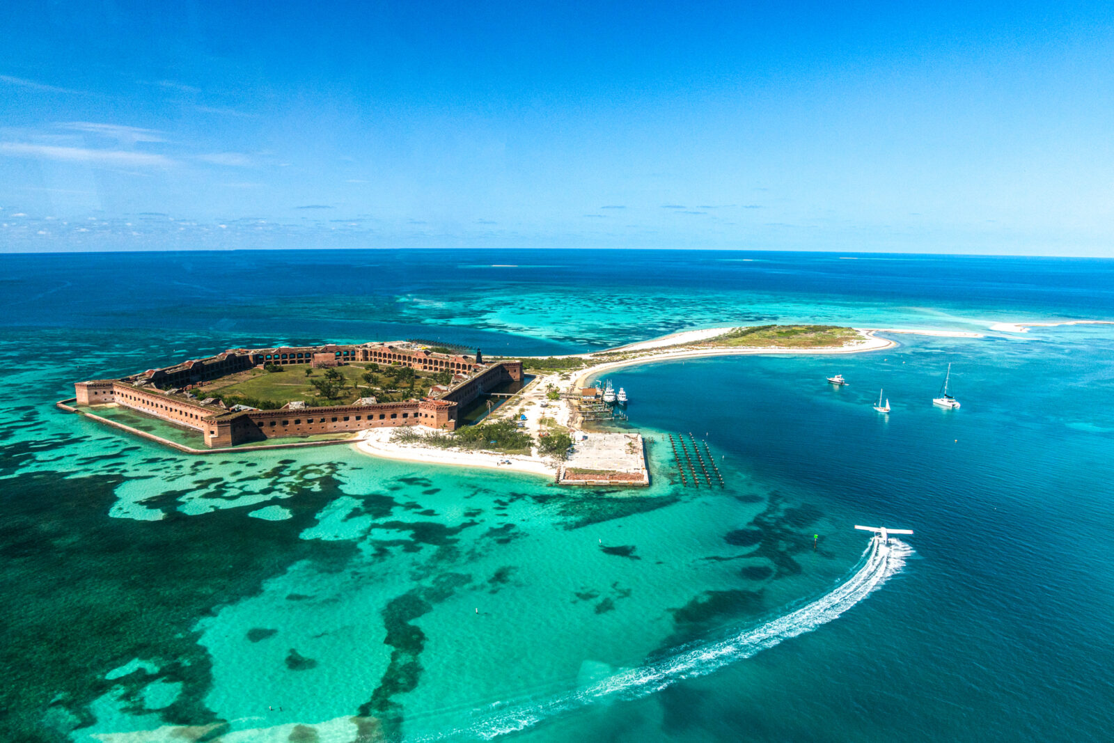 An aerial view of a coastal fortress in aqua water