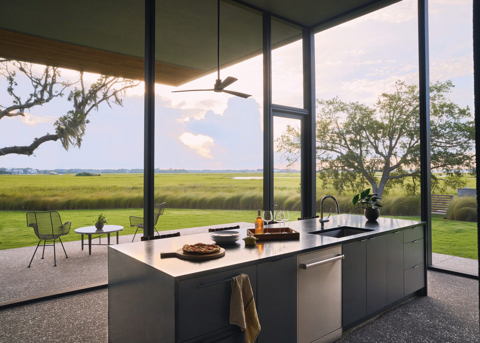 A glass kitchen looks out to the marsh