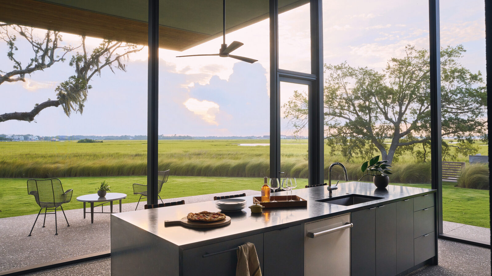 A glass kitchen looks out to the marsh