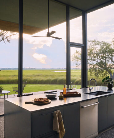 A glass kitchen looks out to the marsh