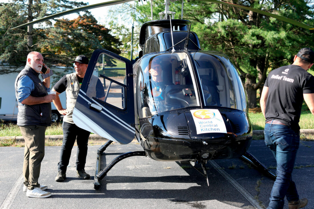 People stand around a helicopter