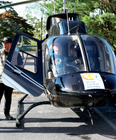 People stand around a helicopter