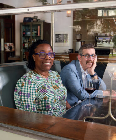 A portrait of a man and a woman in a wood booth of a restaurant