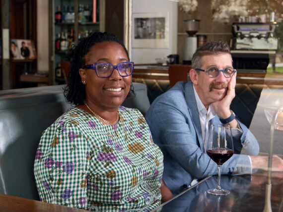 A portrait of a man and a woman in a wood booth of a restaurant