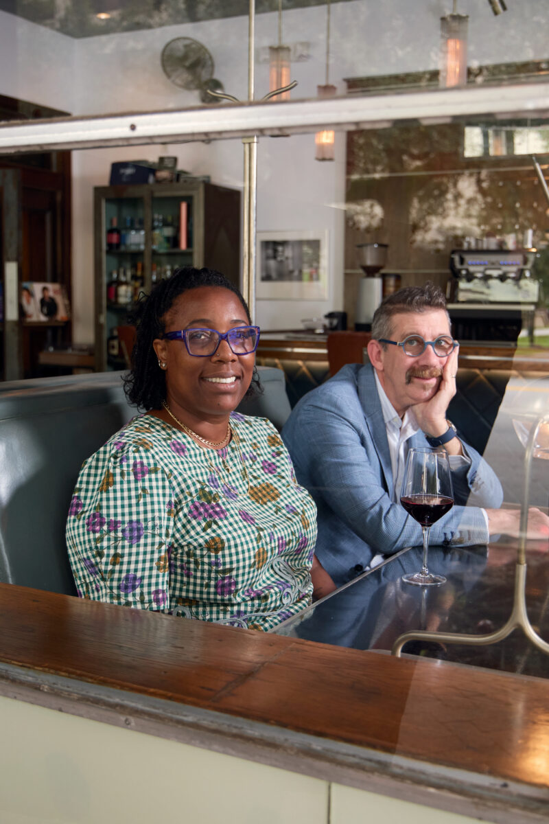 A portrait of a man and a woman in a wood booth of a restaurant