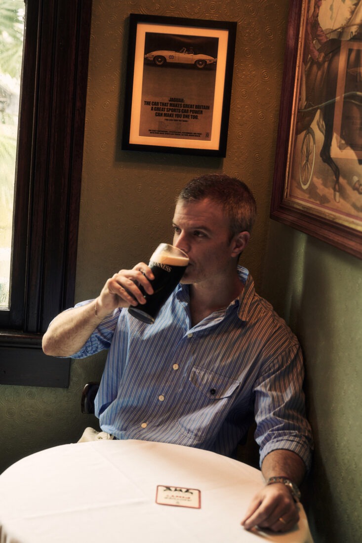 A man drinks a glass of guinness