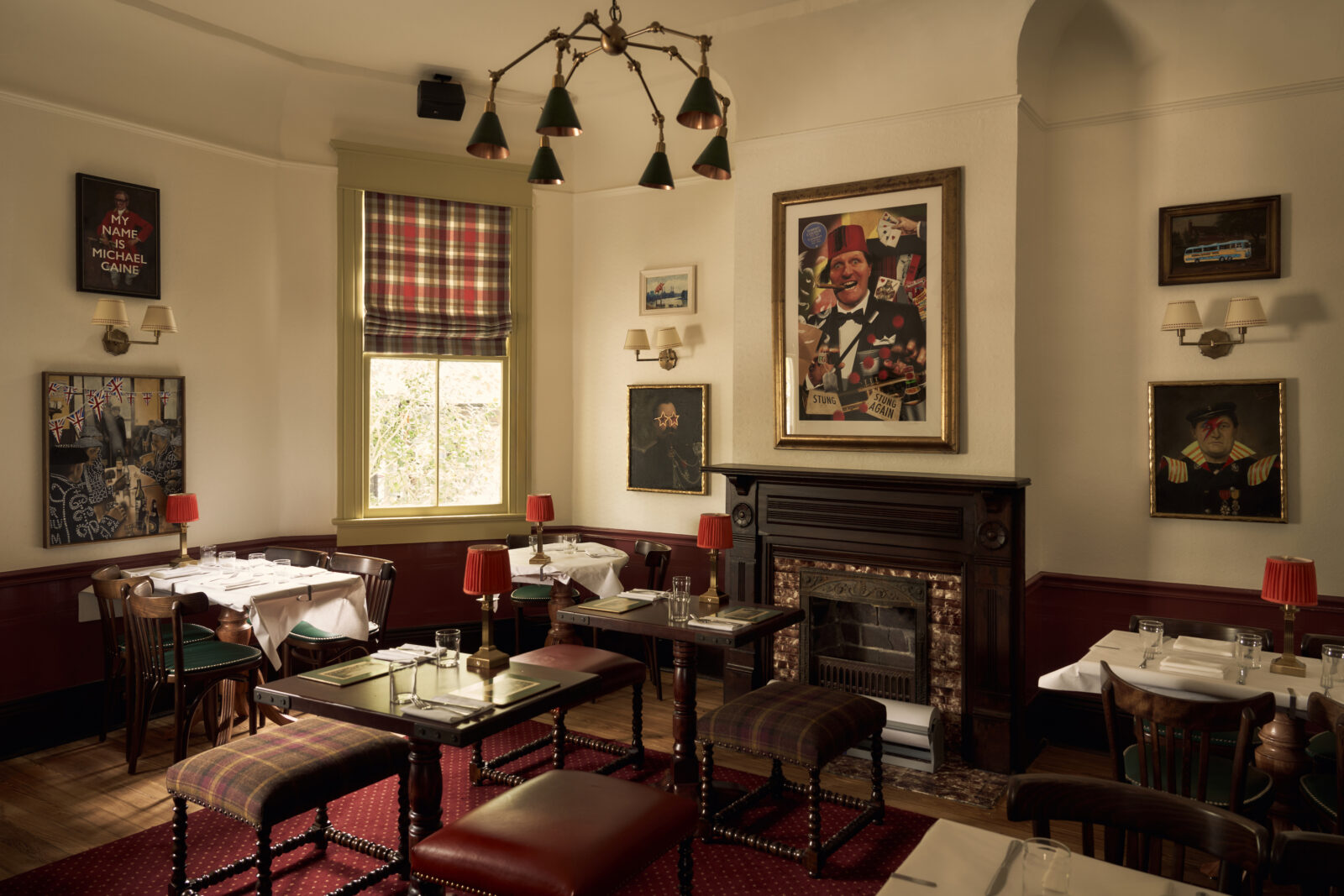 Inside a pub with red accents and portraits of men