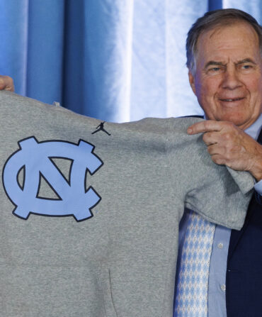 A man holds up a UNC shirt