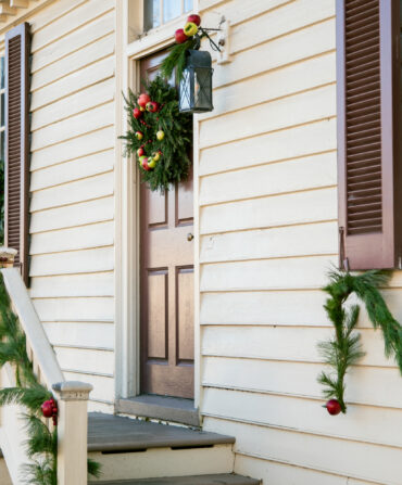 A white house decorated with wreaths for christmas