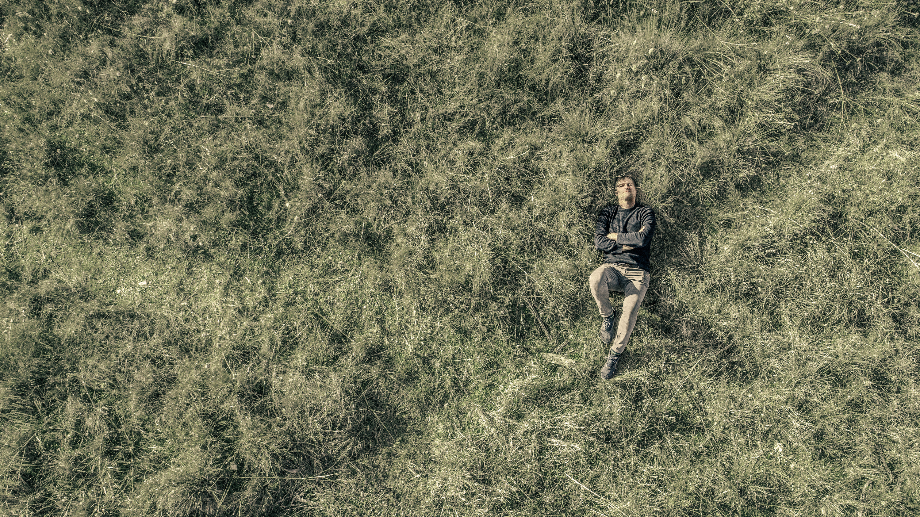 A man lays in grass