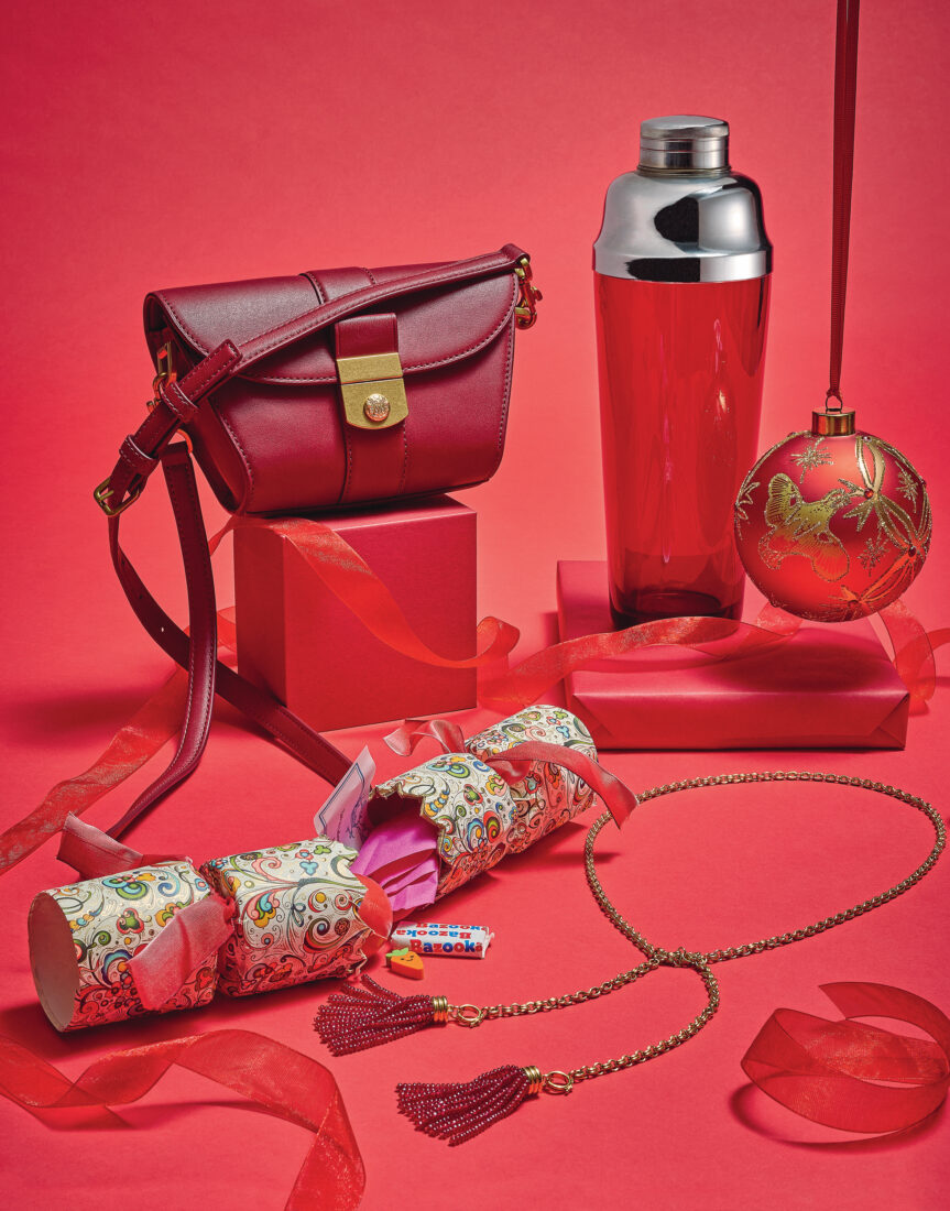 A red purse, ornament, tumbler, fringe necklace, and party cracker