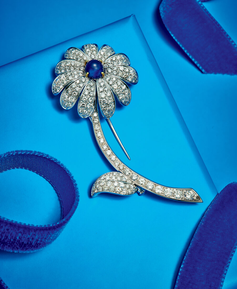 A diamond flower brooch on a blue background