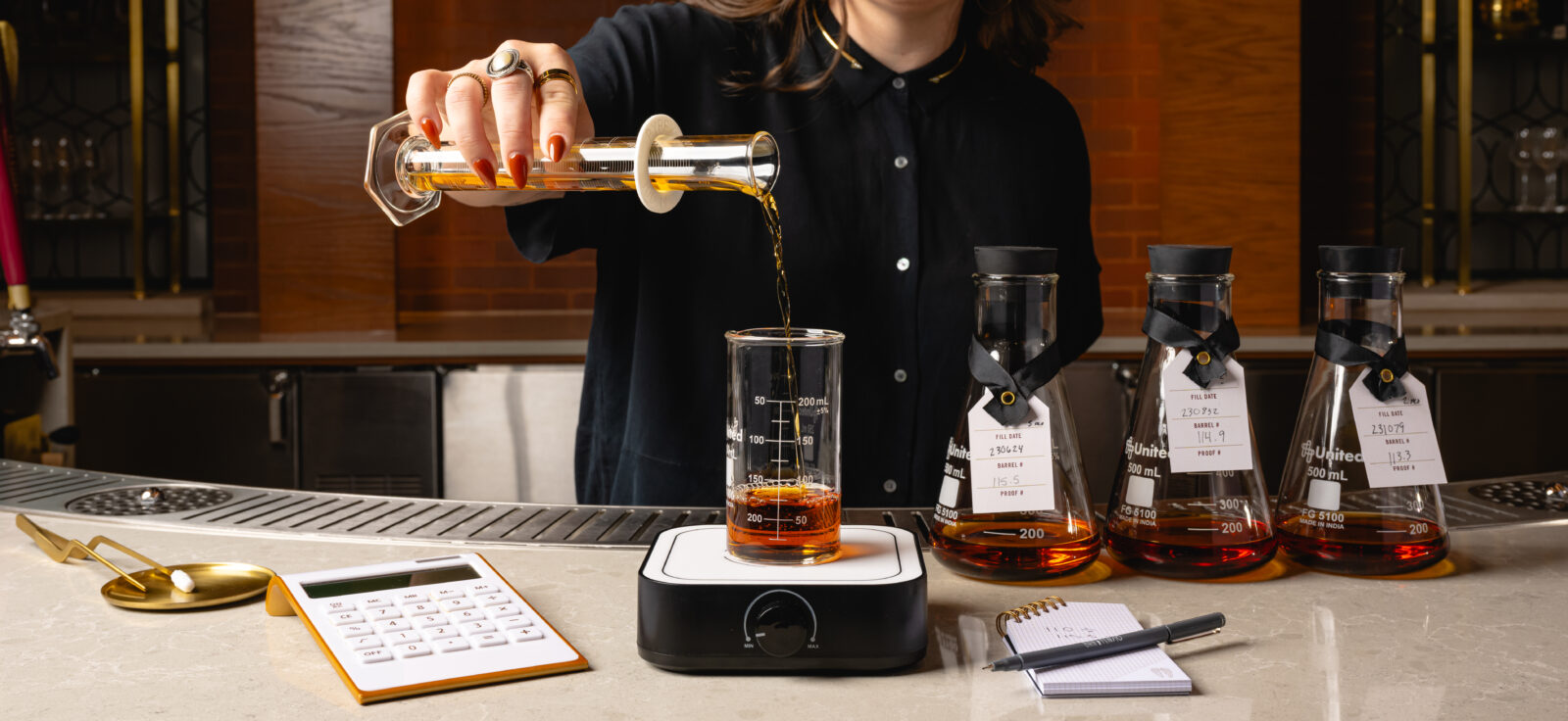 a person pours bourbon into a measuring cup on a scale