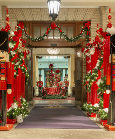 Nutcrackers stand outside a holiday-decorated hotel