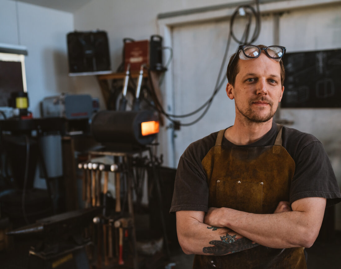 A blacksmith stands in a studio