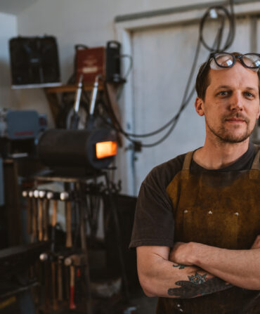 A blacksmith stands in a studio