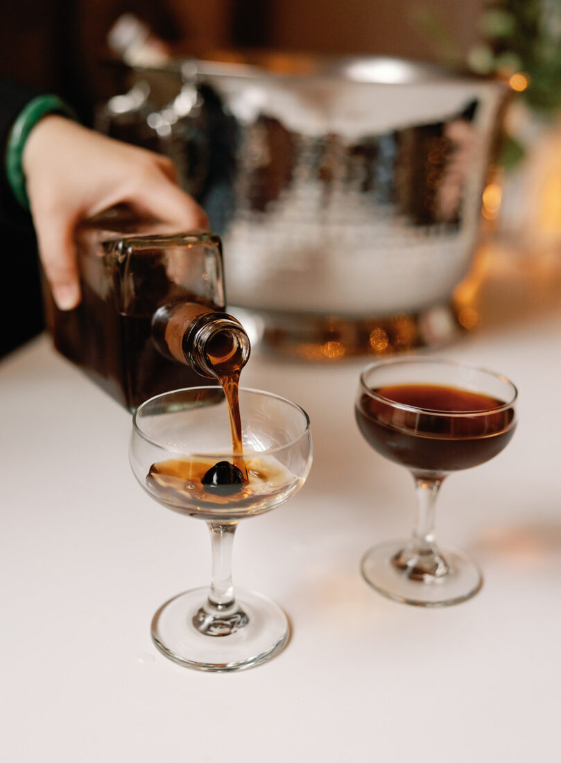 Black Manhattans, composed of Jimmy Red Bourbon bottled in bond, Southern amaro, red vermouth, orange-infused demerara syrup, and bitters.