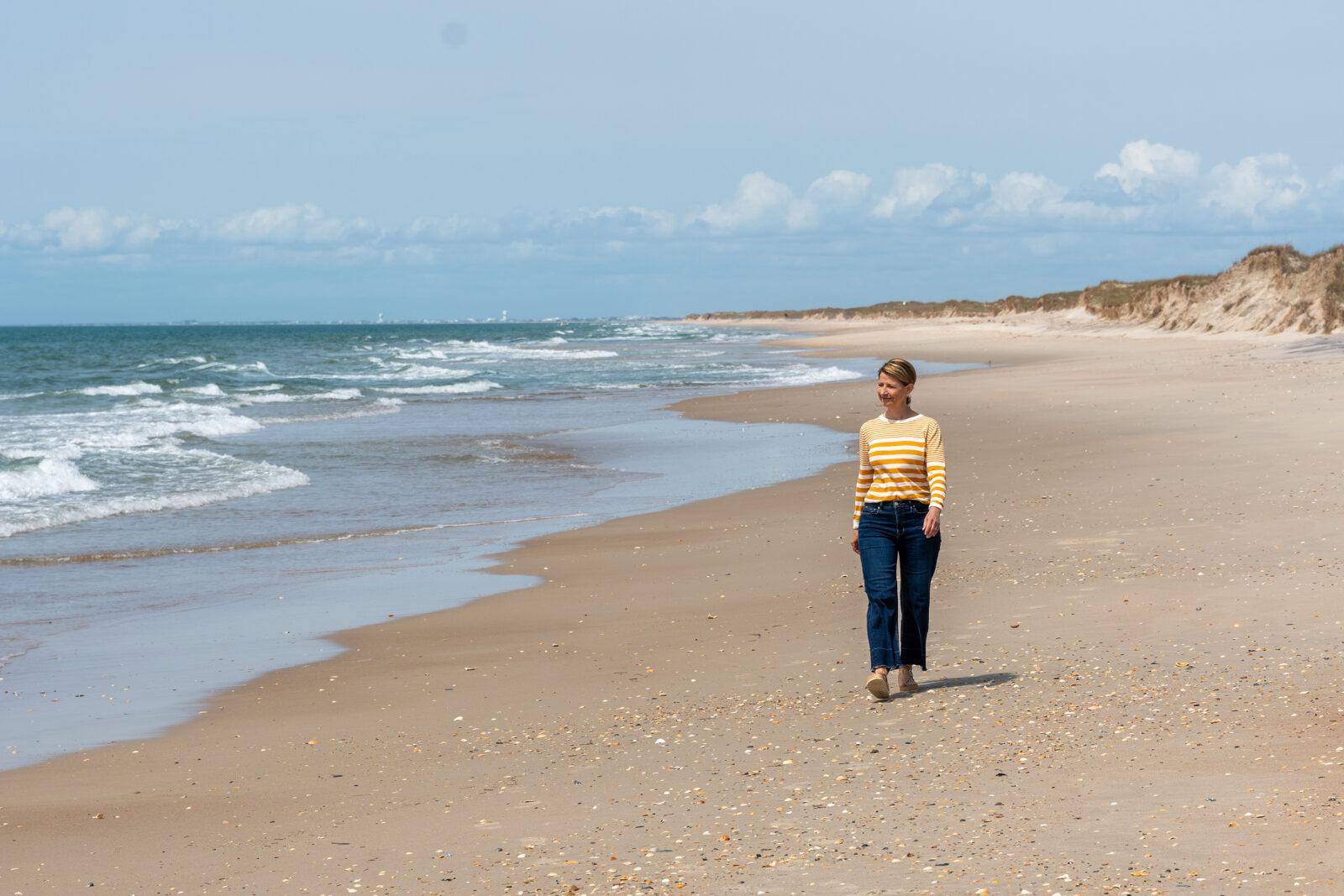 A woman walking along a beach