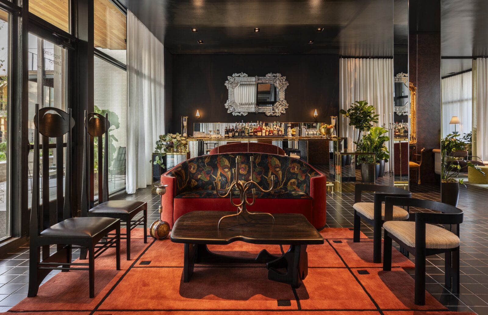 Inside a lobby bar with art deco furniture and a stocked bar with black walls