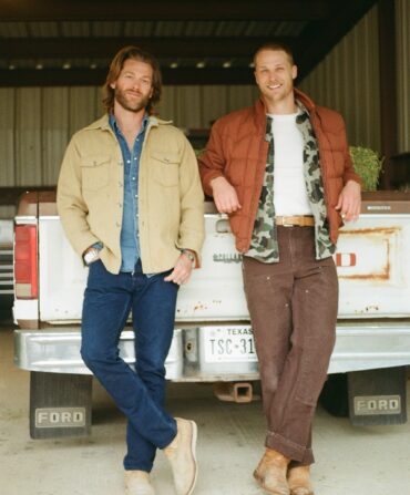 A portrait of two men standing in front of a truck