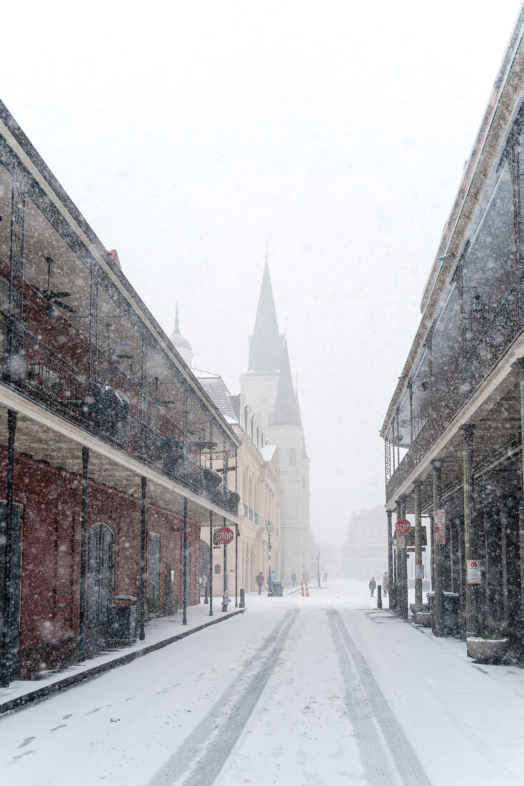 A snowy street with a church on it