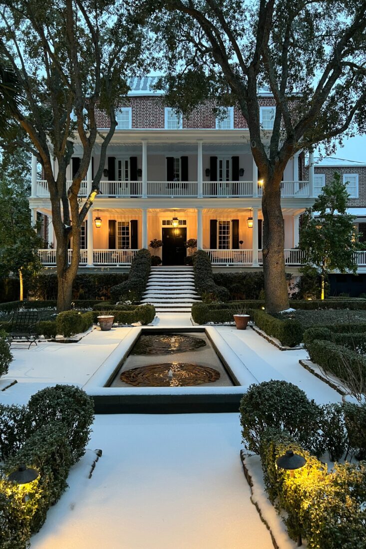 A historic house with a snowy front yard