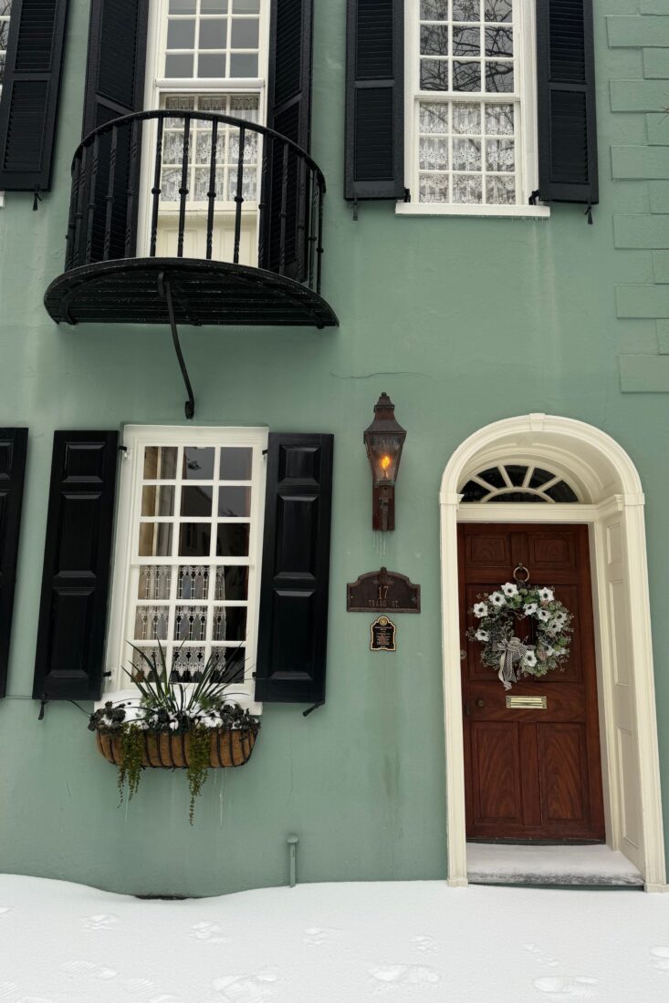 A green townhouse in the snow