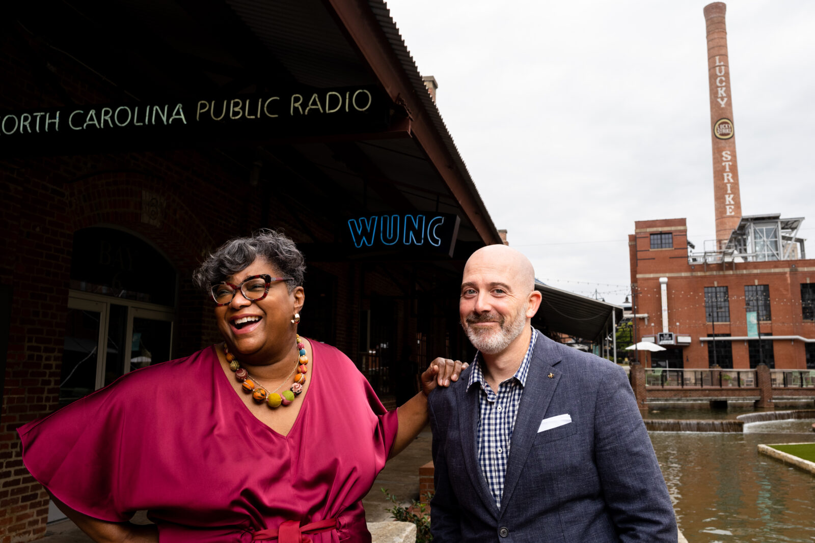 A man and woman stand outside a radio station