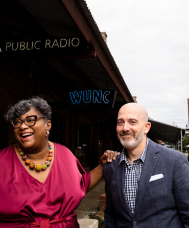 A man and woman stand outside a radio station